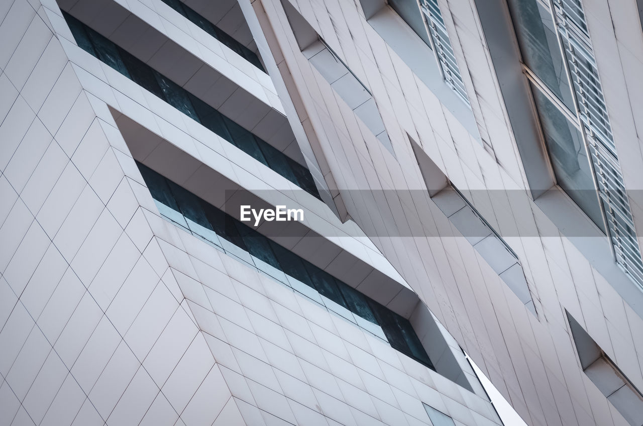 LOW ANGLE VIEW OF GLASS BUILDING AGAINST SKY