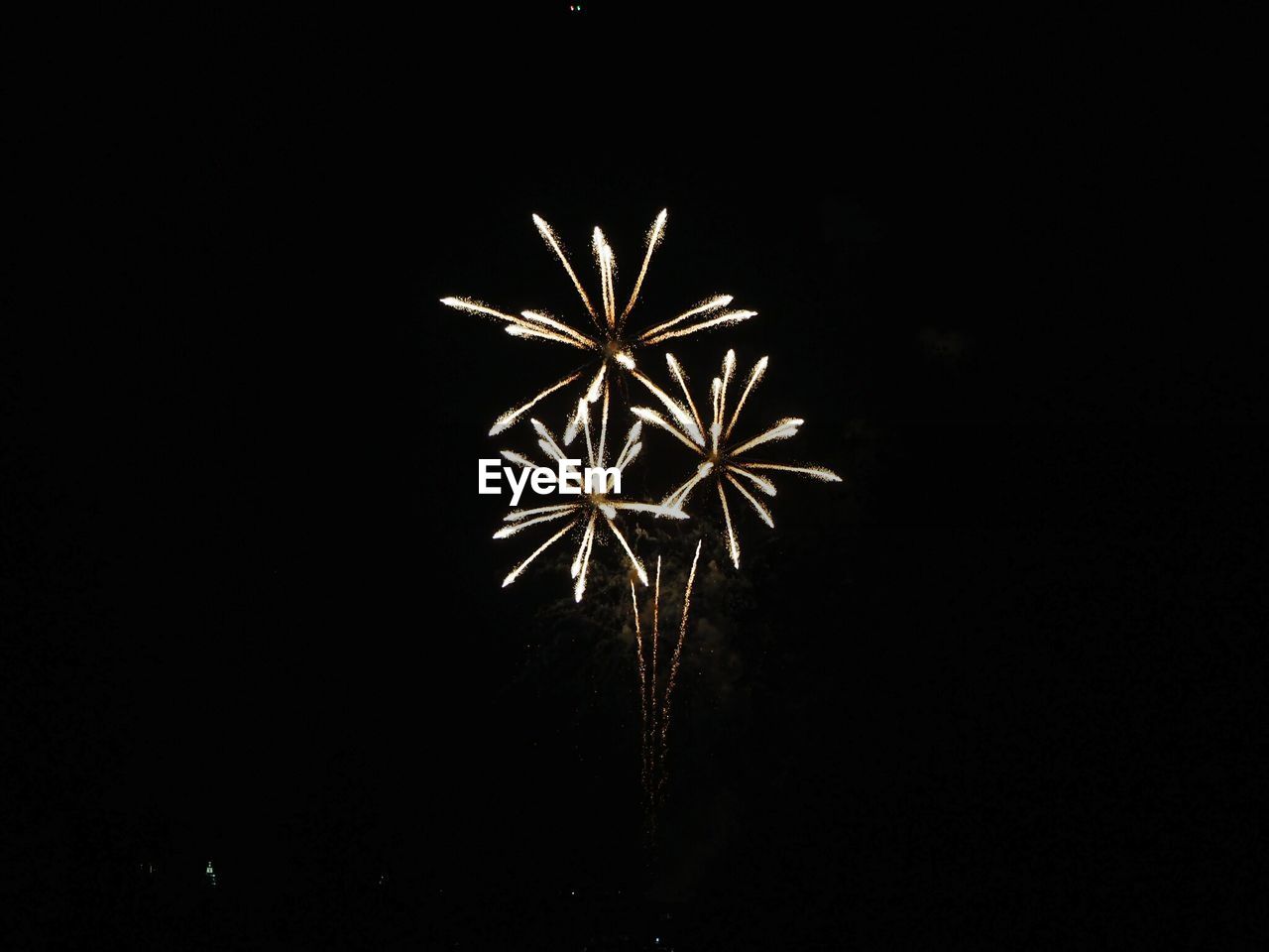LOW ANGLE VIEW OF FIREWORK DISPLAY AT NIGHT