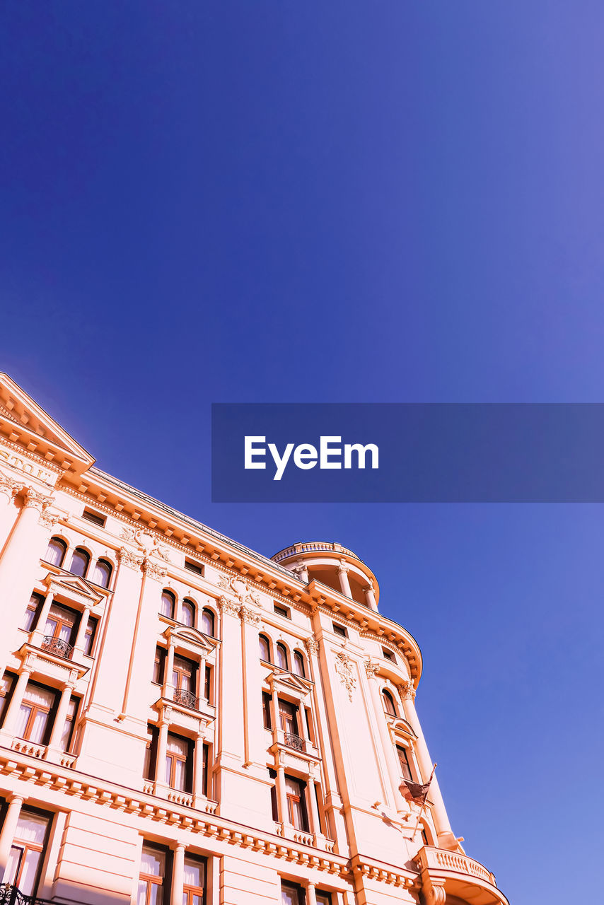 LOW ANGLE VIEW OF HISTORIC BUILDING AGAINST BLUE SKY