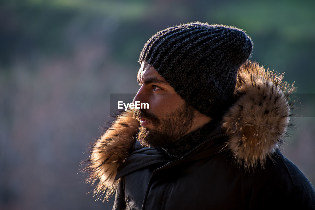 Portrait of young man looking away outdoors