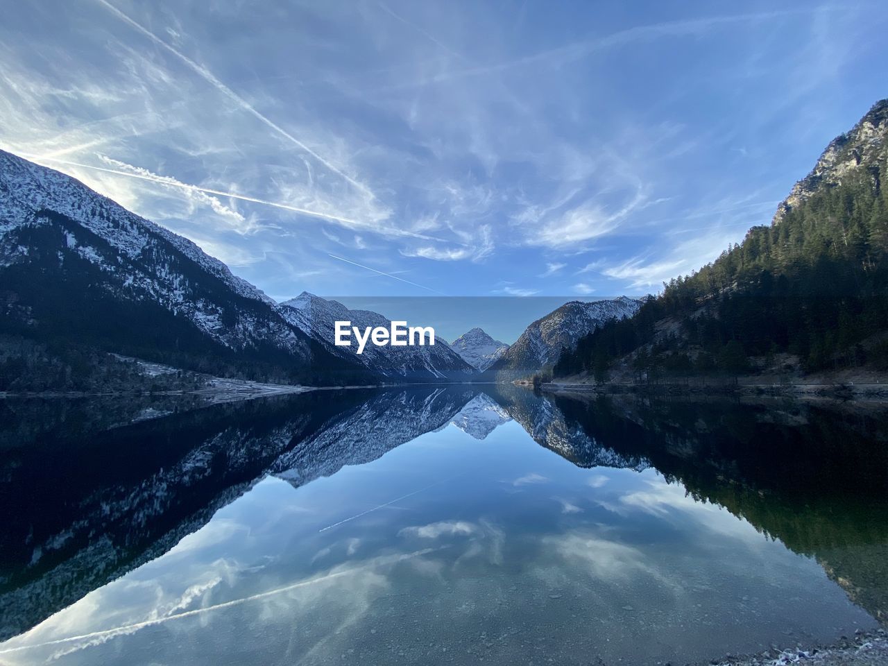 Scenic view of lake by mountains against sky