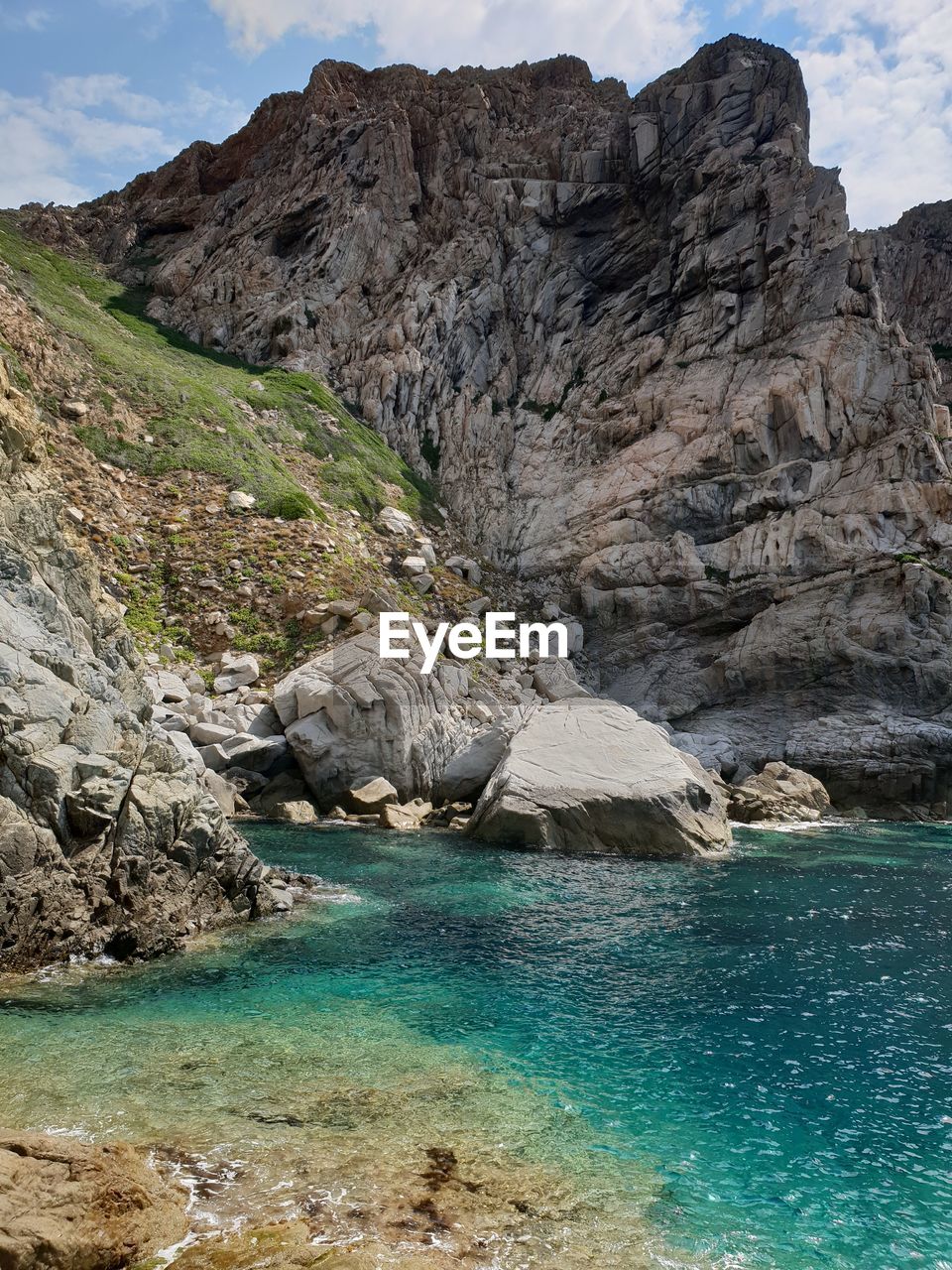 Scenic view of rocks and sea against mountains