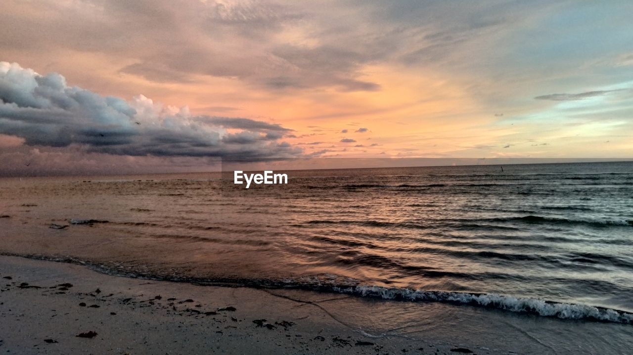 SCENIC VIEW OF BEACH DURING SUNSET