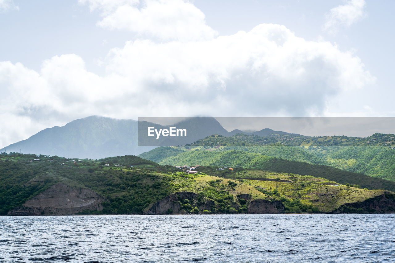 Scenic view of sea and mountains against sky