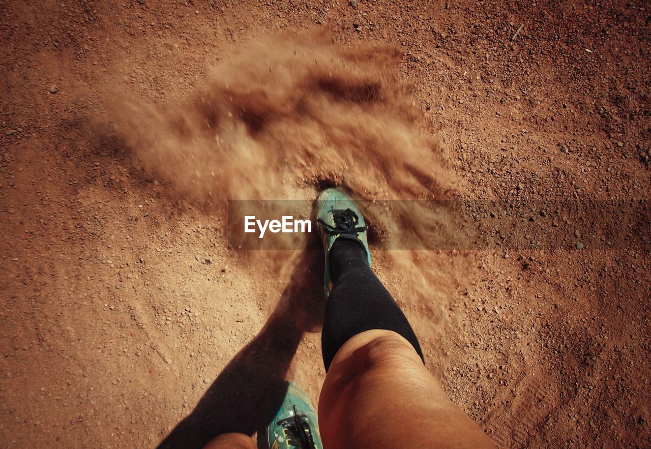 Low section of woman running on baseball field 