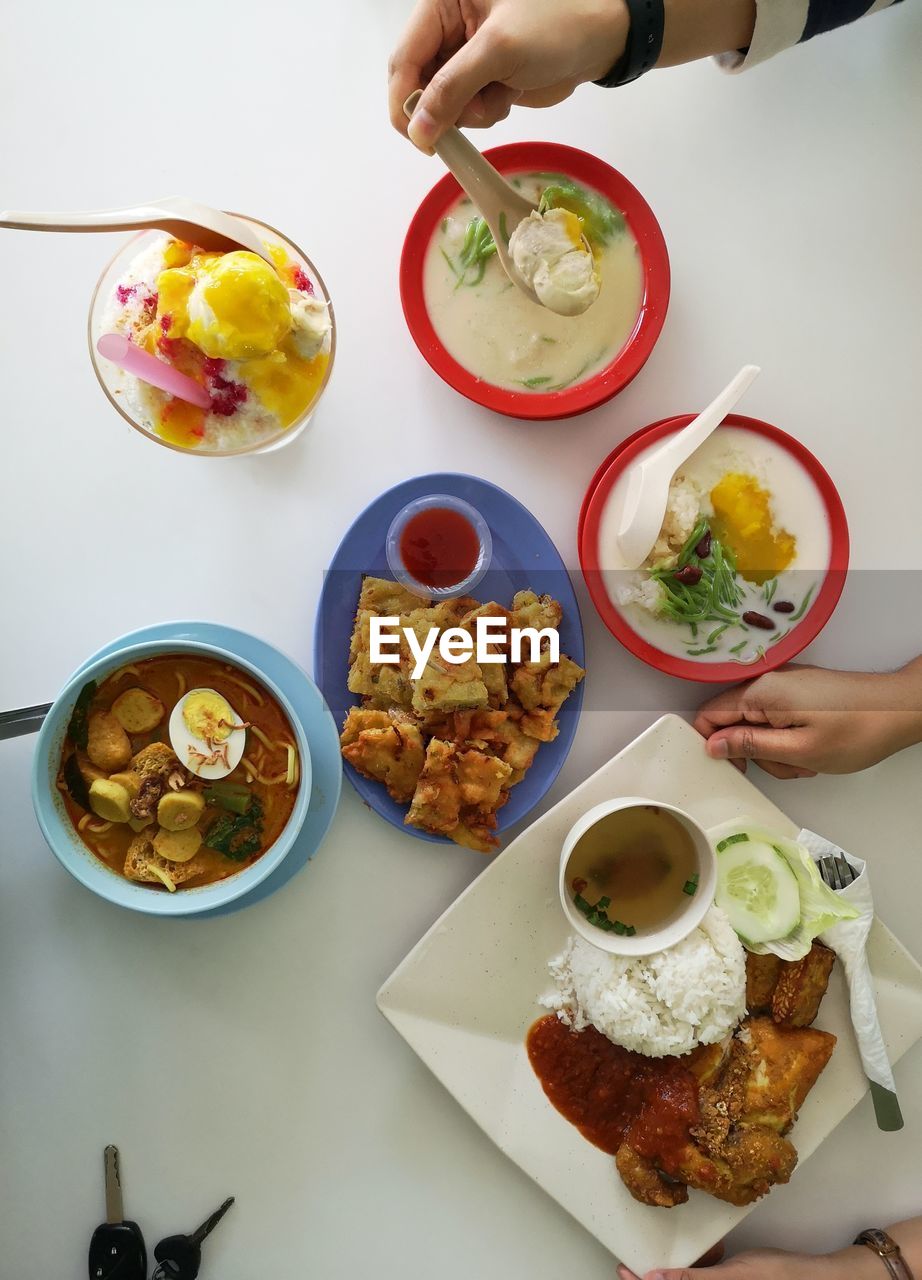 Cropped hands having food at table