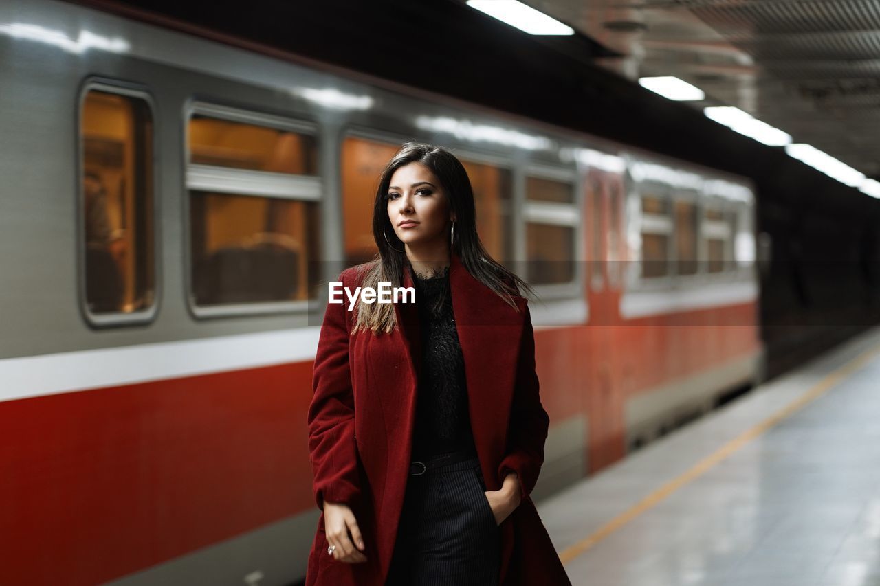 Portrait of beautiful woman standing at railway station