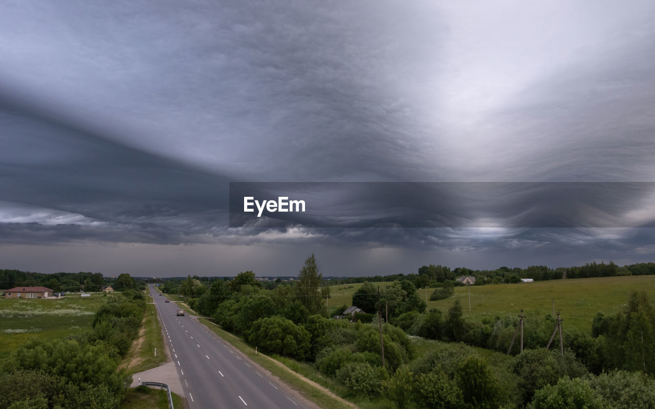 cloud, sky, environment, road, plant, landscape, tree, storm, transportation, nature, beauty in nature, dramatic sky, storm cloud, scenics - nature, land, no people, thunderstorm, horizon, city, cloudscape, overcast, outdoors, highway, street, travel, rural scene, rain, sign, architecture, moody sky, motion, wet, field, travel destinations, the way forward