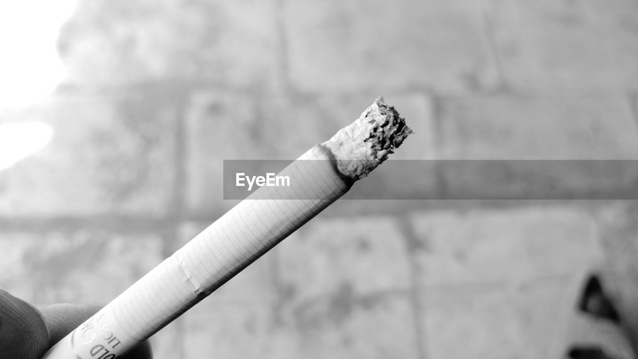 CLOSE-UP OF CIGARETTE ON WOOD