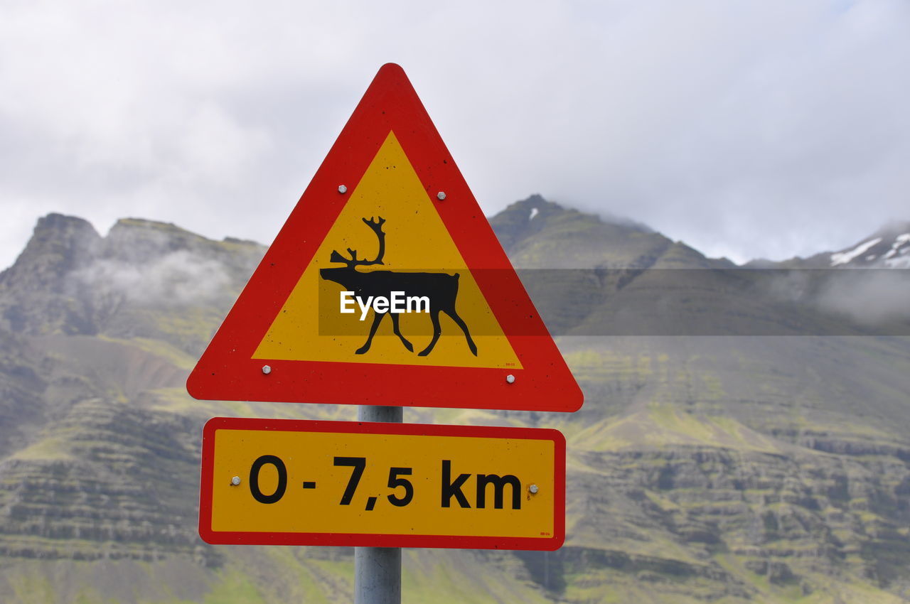 ROAD SIGN AGAINST MOUNTAIN