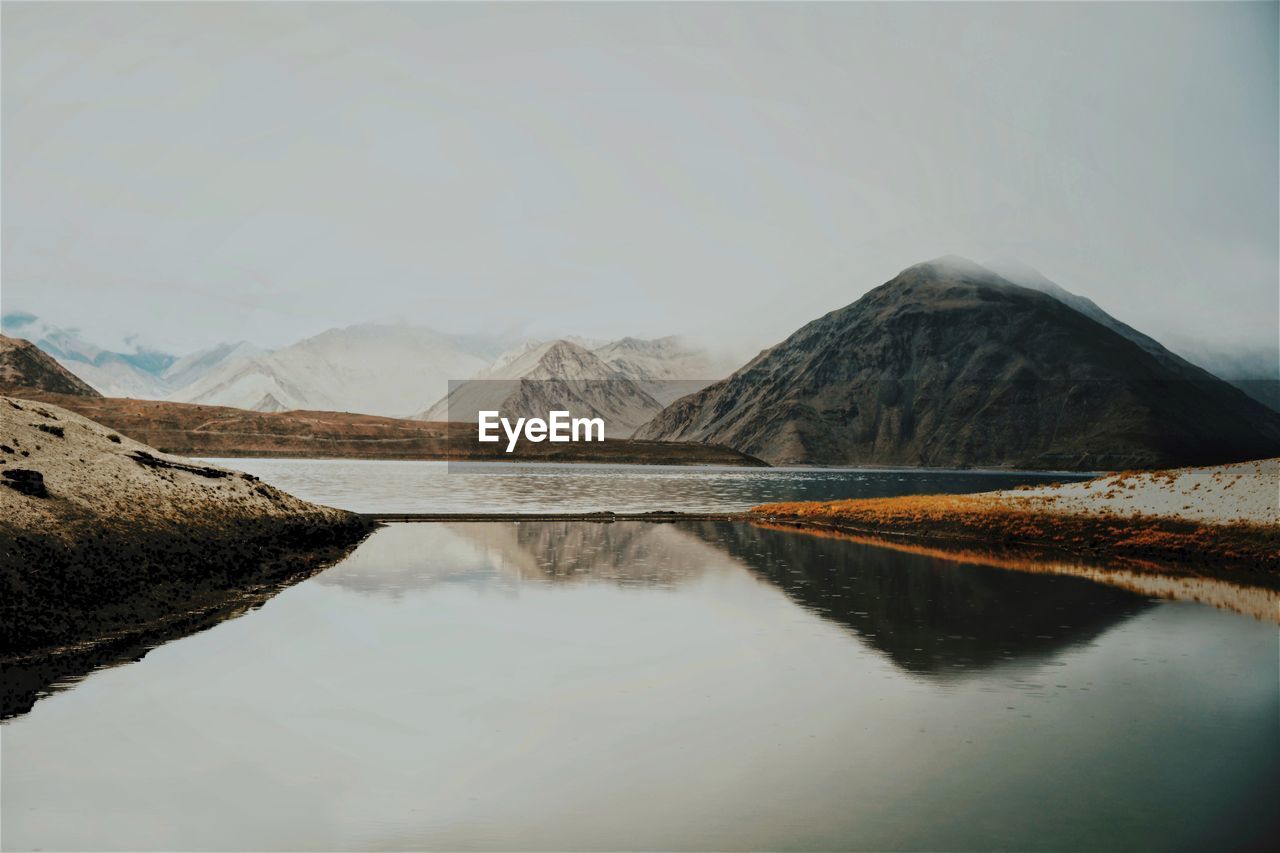 Idyllic view of rocky mountains and lake against sky