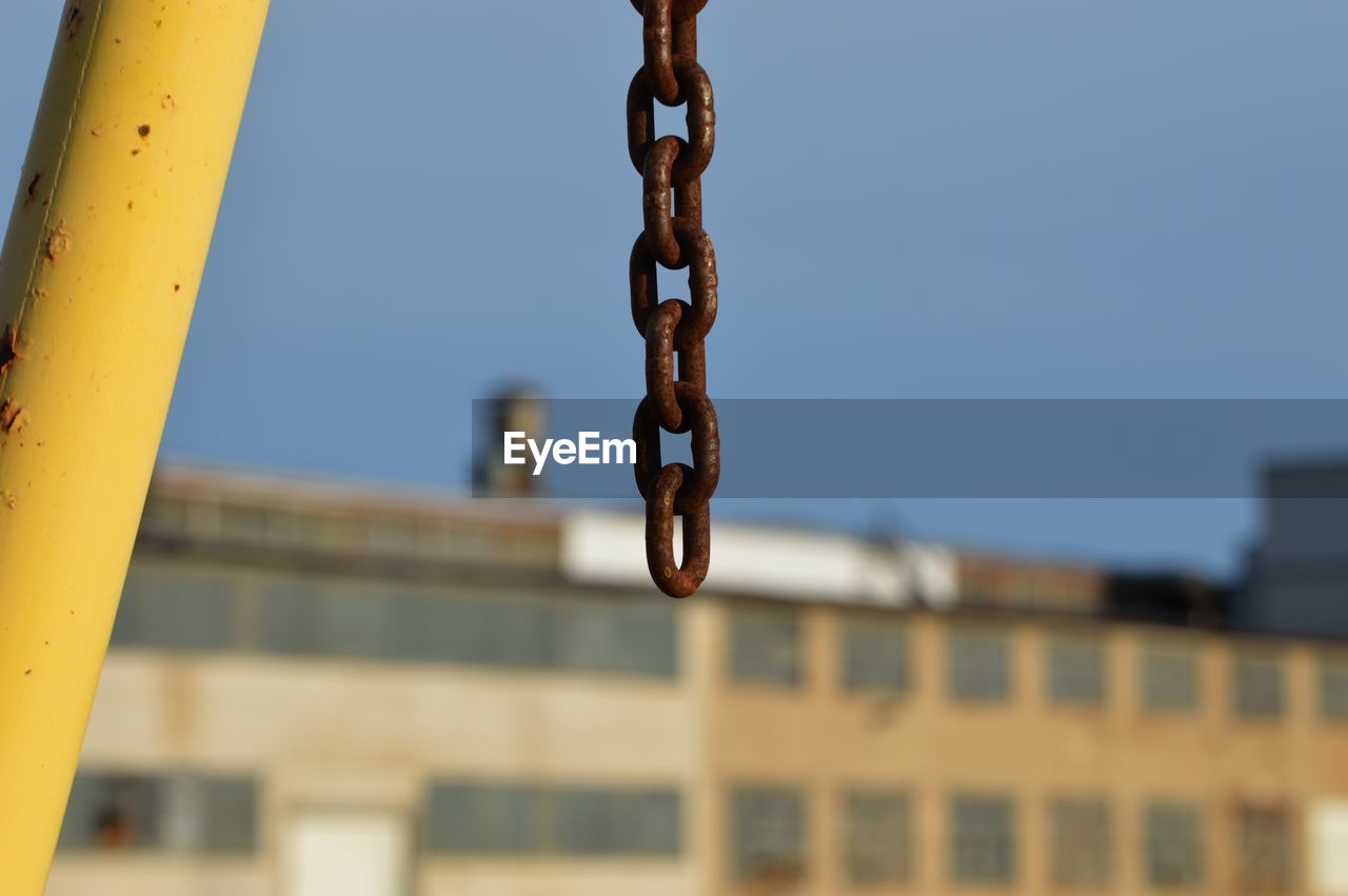 Low angle view of chain against building