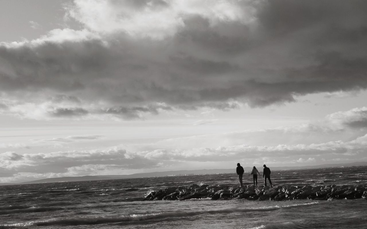 People on rocks at sea