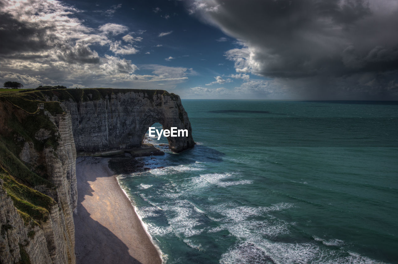 Idyllic shot of rock formation in sea against sky at etretat