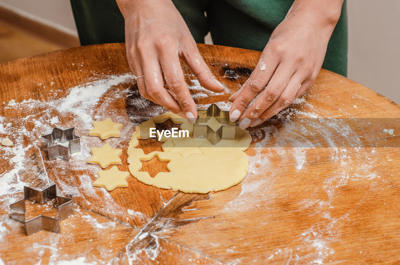 The cook kneads the cookie dough with his hands