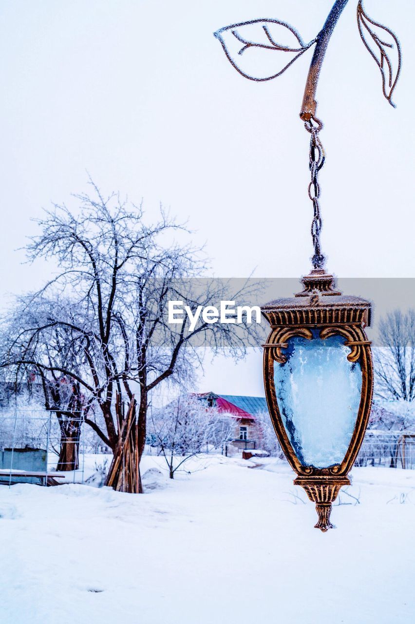 SNOW COVERED BARE TREE AGAINST SKY