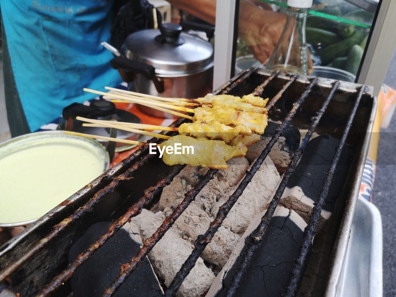 Close-up of person preparing food on barbecue grill