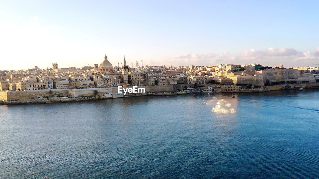 VIEW OF BUILDINGS BY RIVER AGAINST SKY