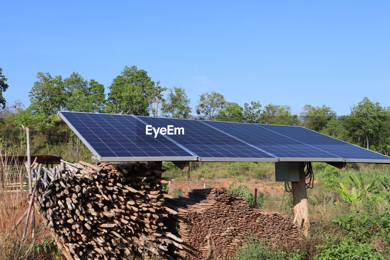 Solar panels on field against clear blue sky