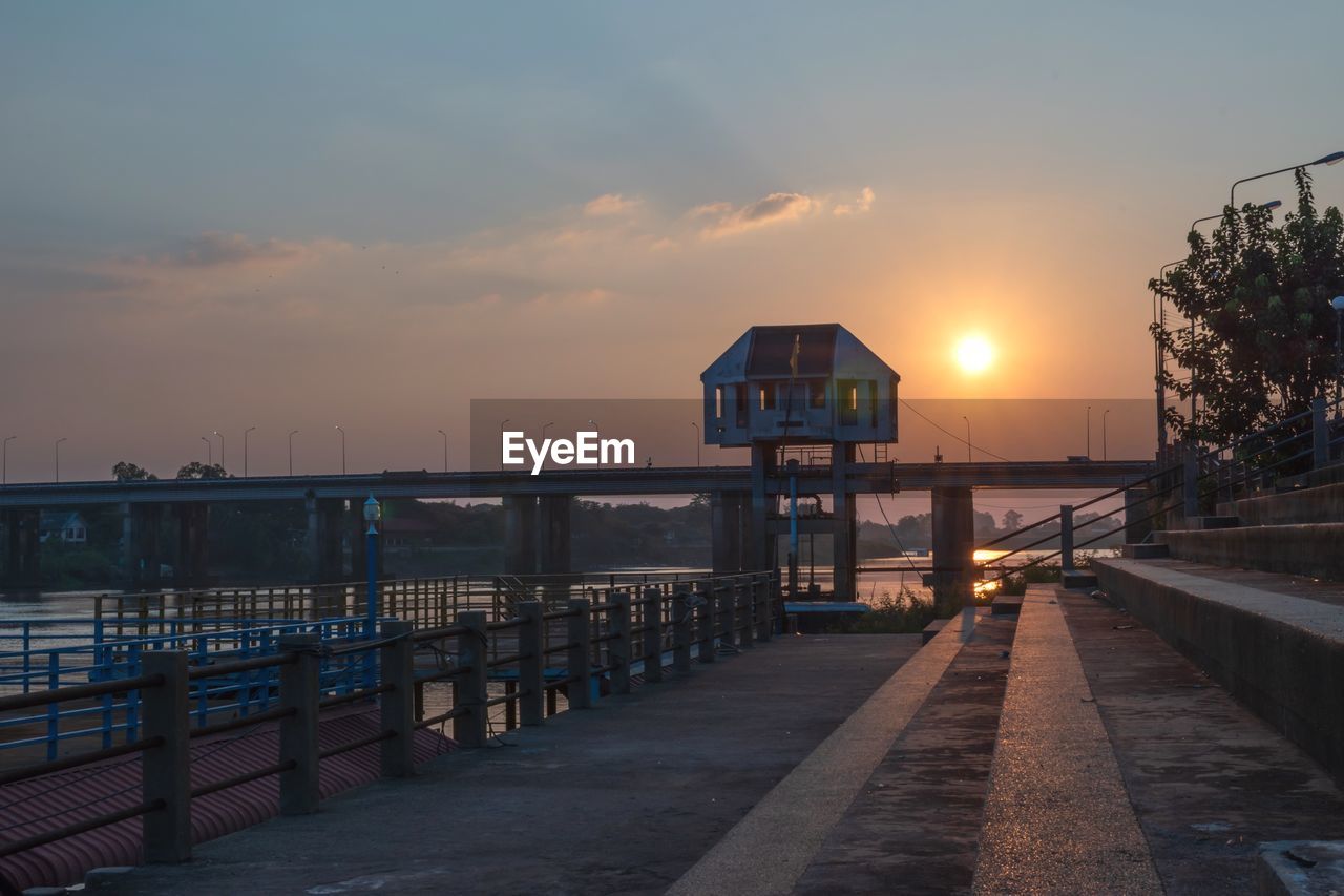 BRIDGE OVER SEA AGAINST SKY AT SUNSET