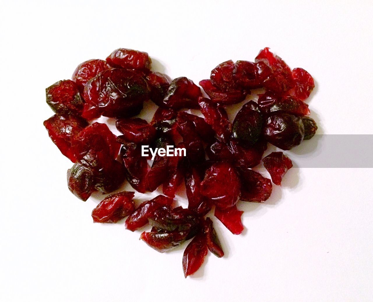 CLOSE-UP OF RED ROSE OVER WHITE BACKGROUND