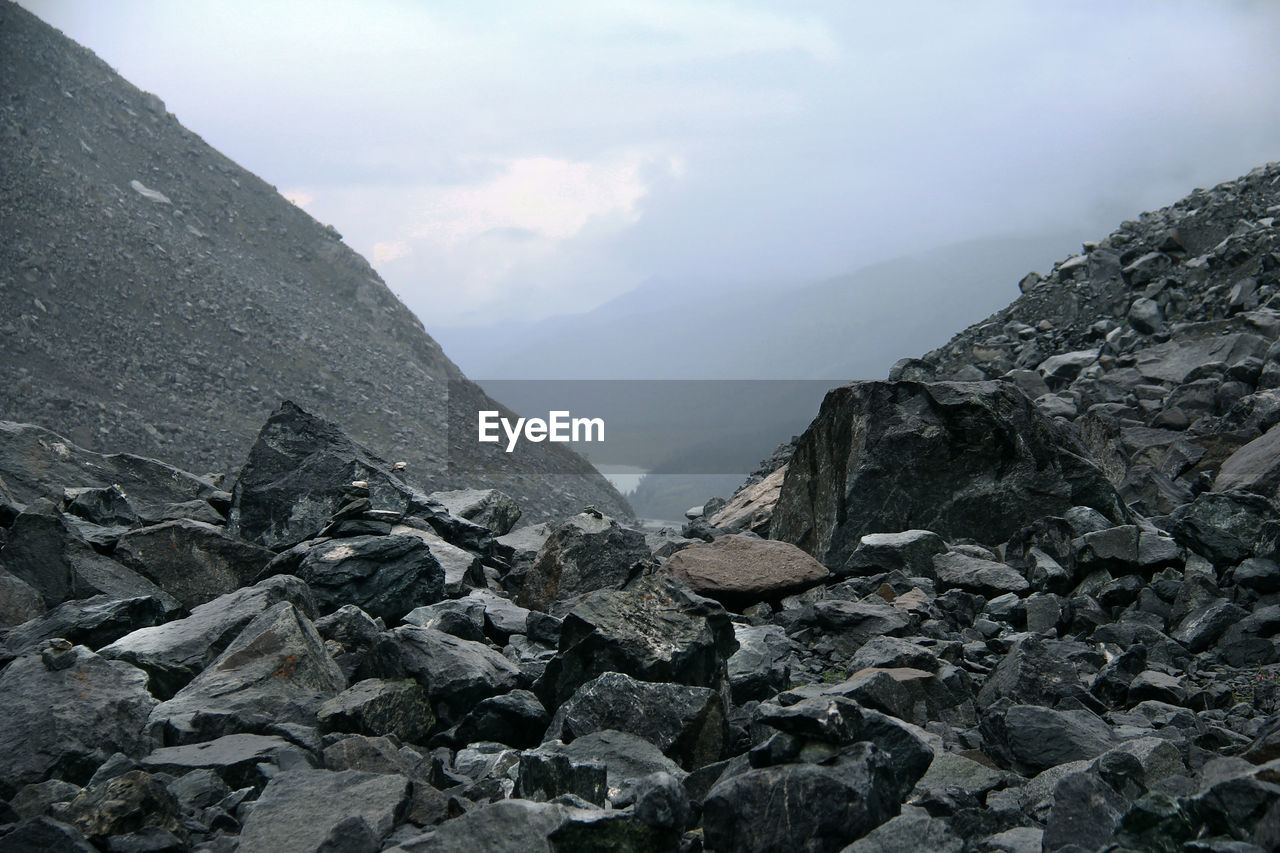 mountain, cloud, ridge, sky, environment, rock, landscape, nature, scenics - nature, mountain range, beauty in nature, summit, geology, rubble, land, no people, outdoors, fog, wilderness, moraine, non-urban scene, day, adventure, tranquility, travel, travel destinations, mountain pass, activity, stone