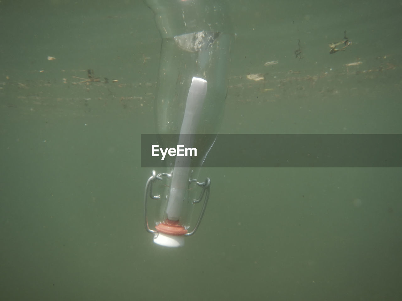 View of glass bottle with message sinking in water