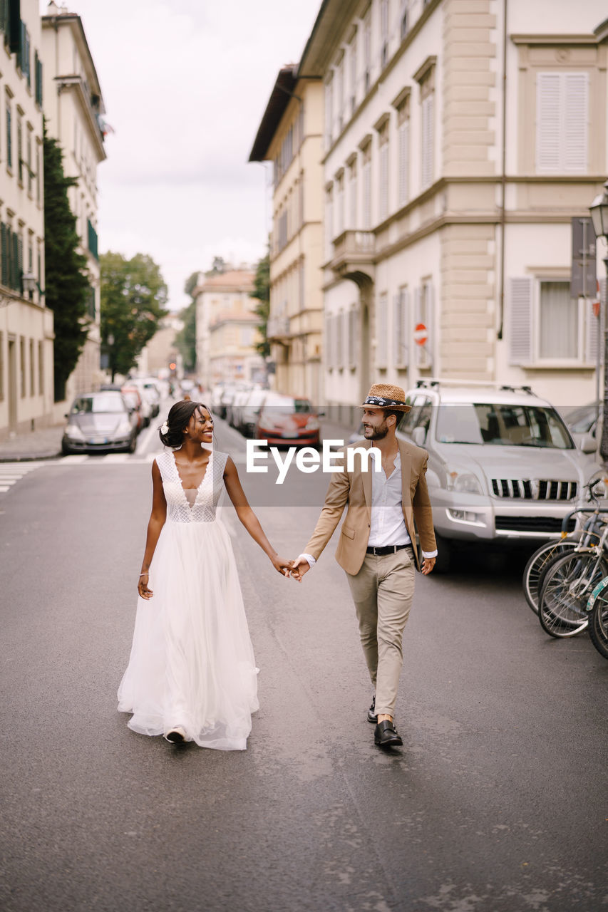 Couple holding hand walking on street