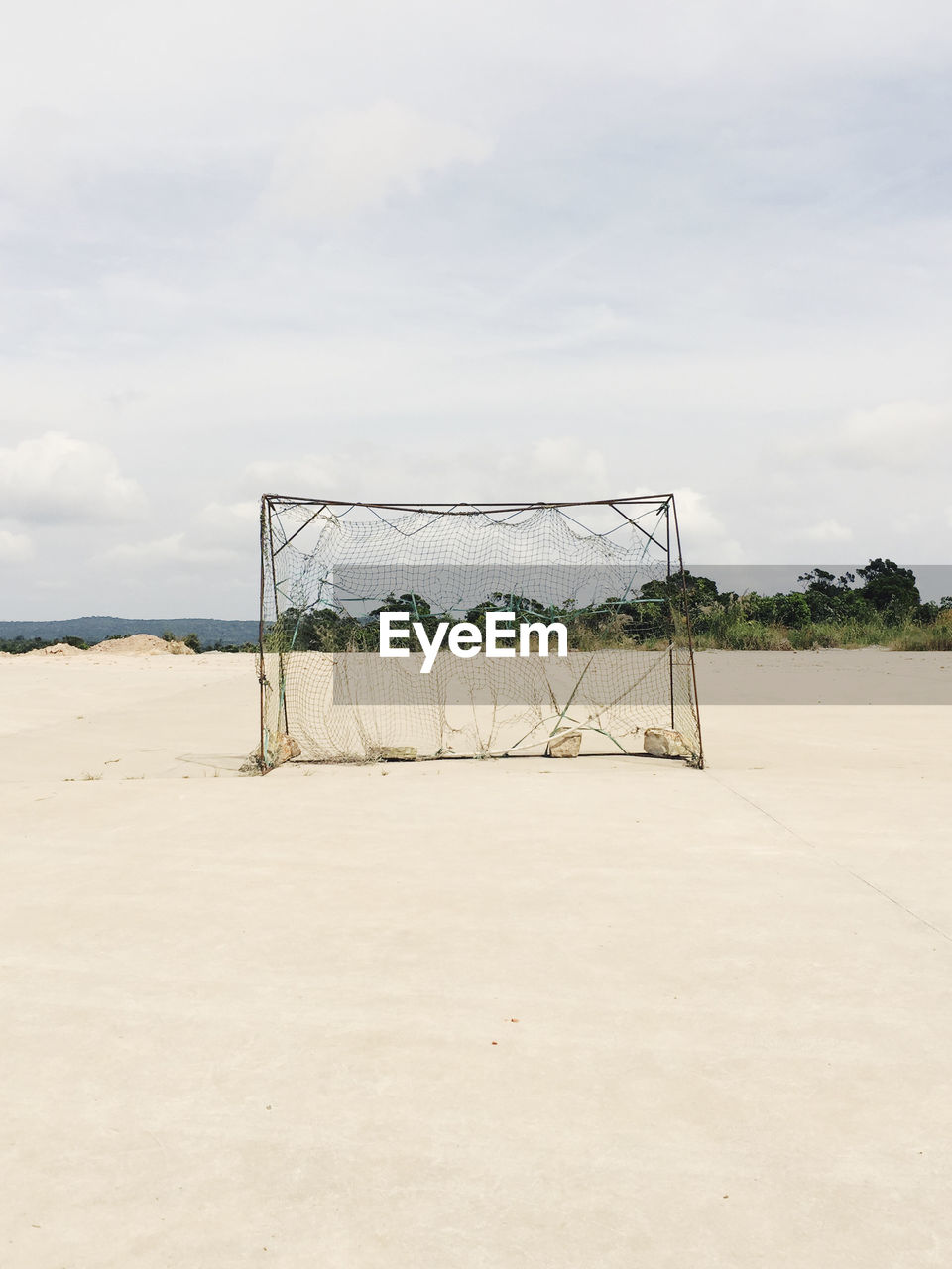 Soccer goal at beach against sky