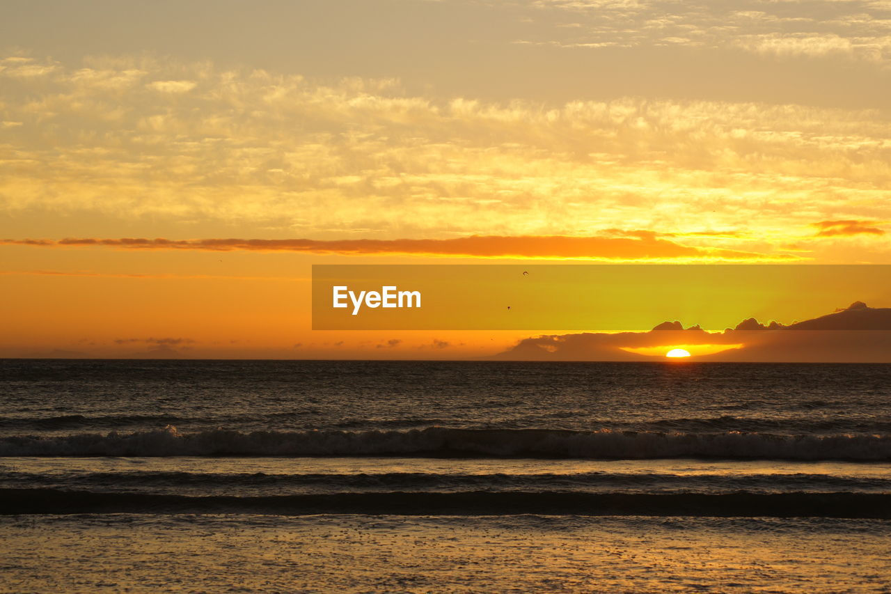 View of calm beach at sunset