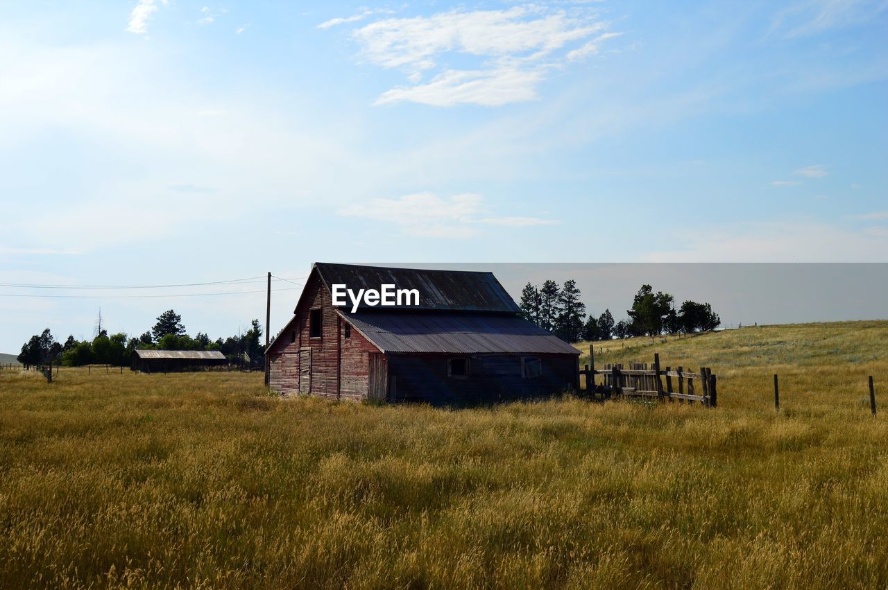 HOUSES ON FIELD AGAINST SKY