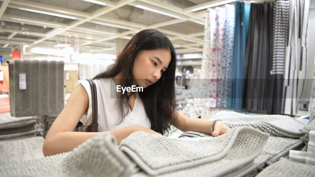 Young woman buying doormat