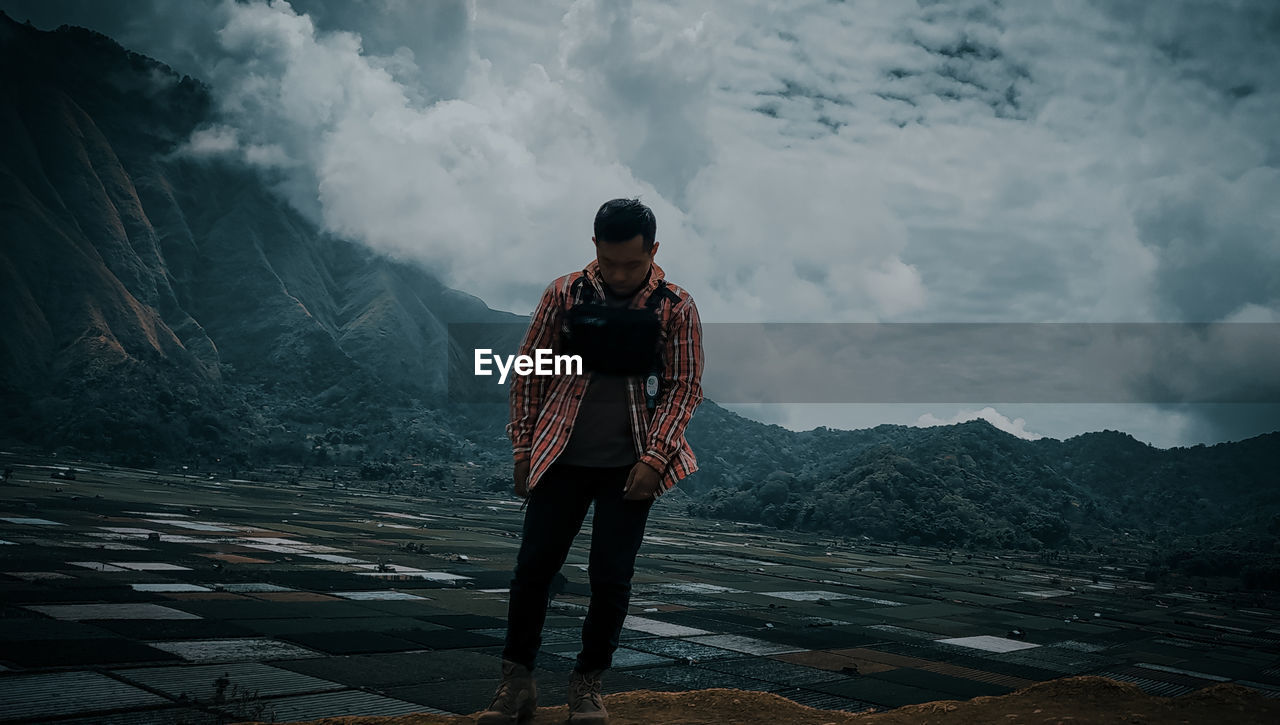 Man standing on mountain against sky