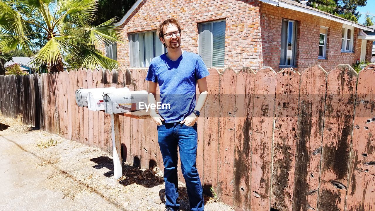 FULL LENGTH PORTRAIT OF MAN STANDING ON BUILDING