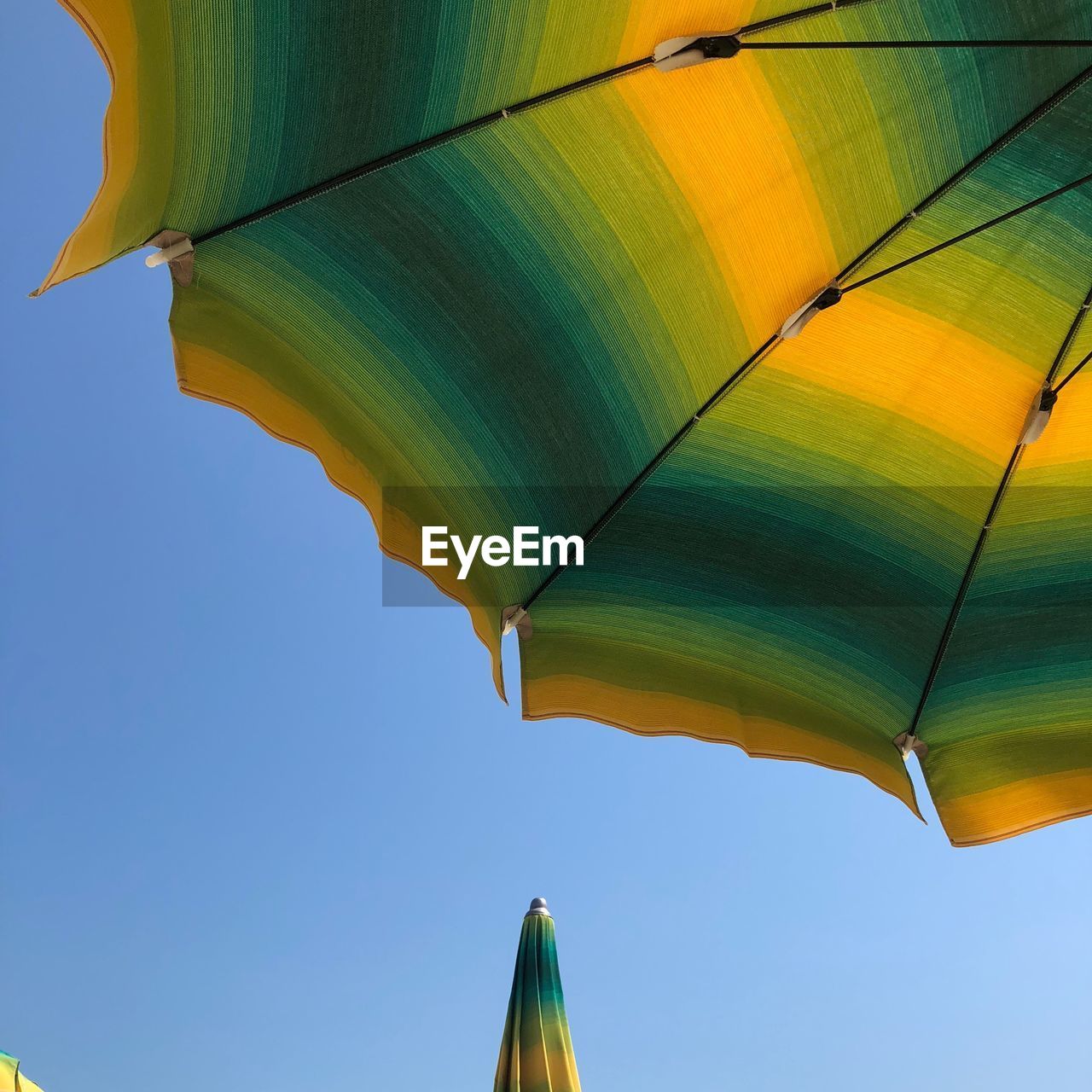 Low angle view of parasol against clear sky