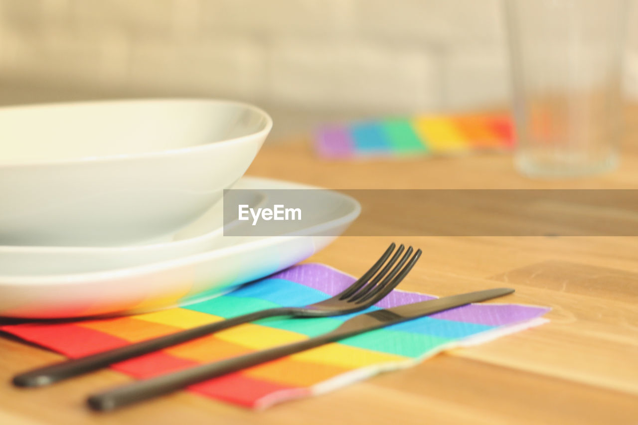 Preparing diner table during pride month. using lgbt's flag colored napkins.