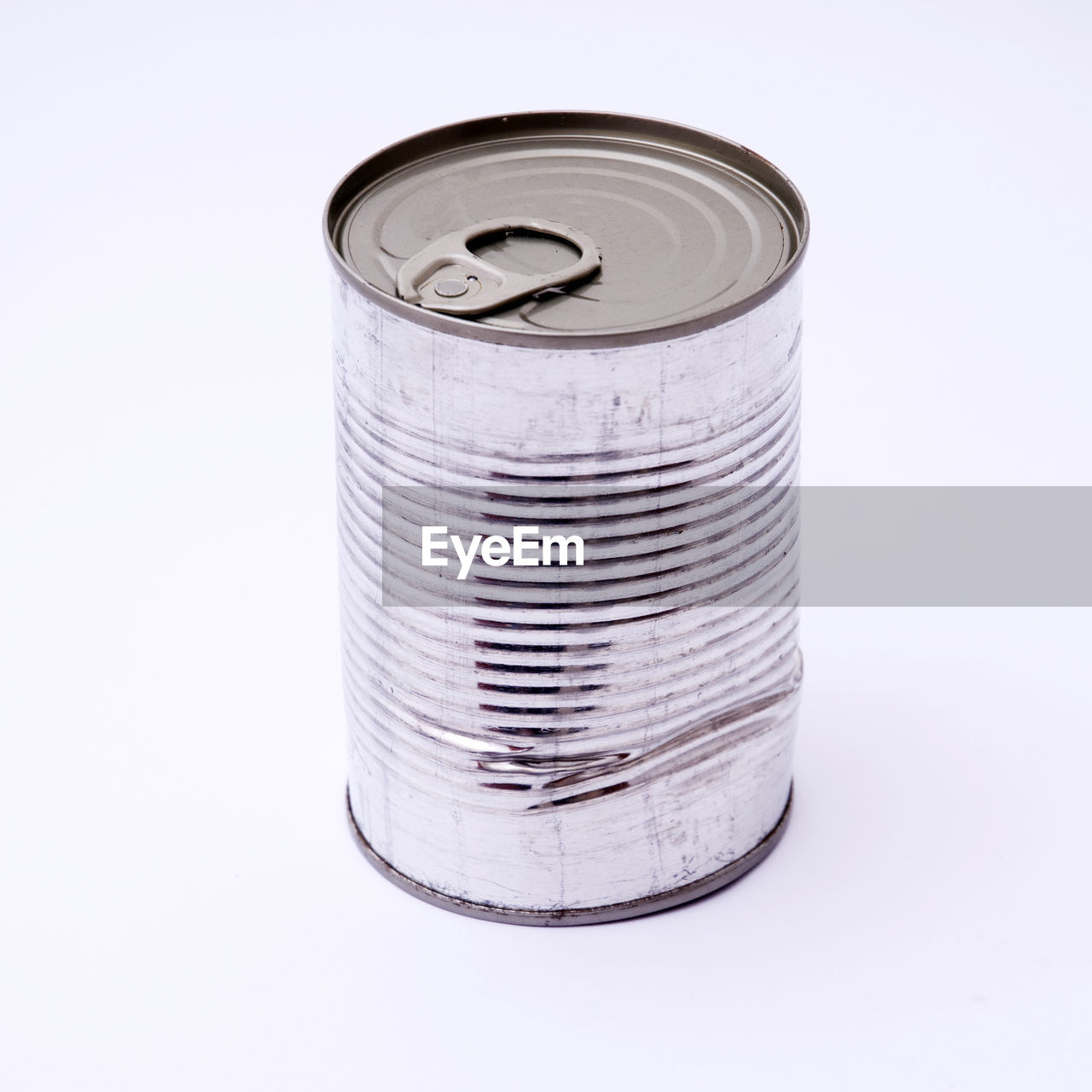 Close-up of dented can against white background