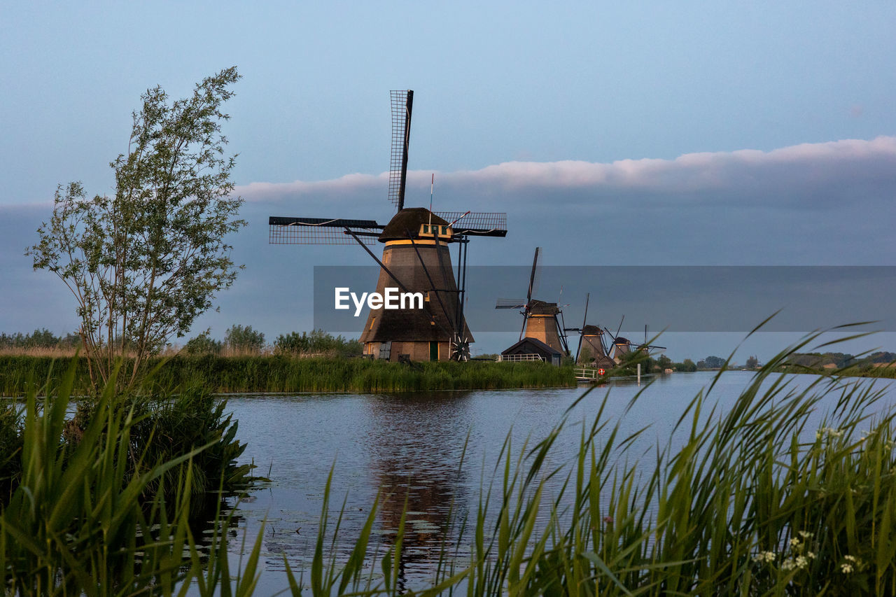 Beautiful wooden windmills at sunset in the dutch village of kinderdijk. windmills run on the wind.