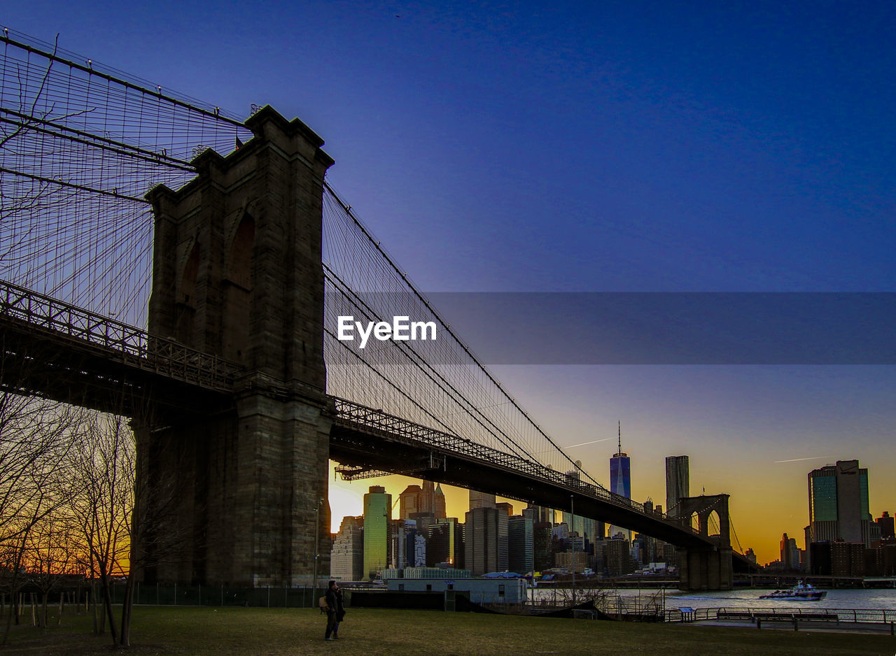 LOW ANGLE VIEW OF SUSPENSION BRIDGE AT SUNSET