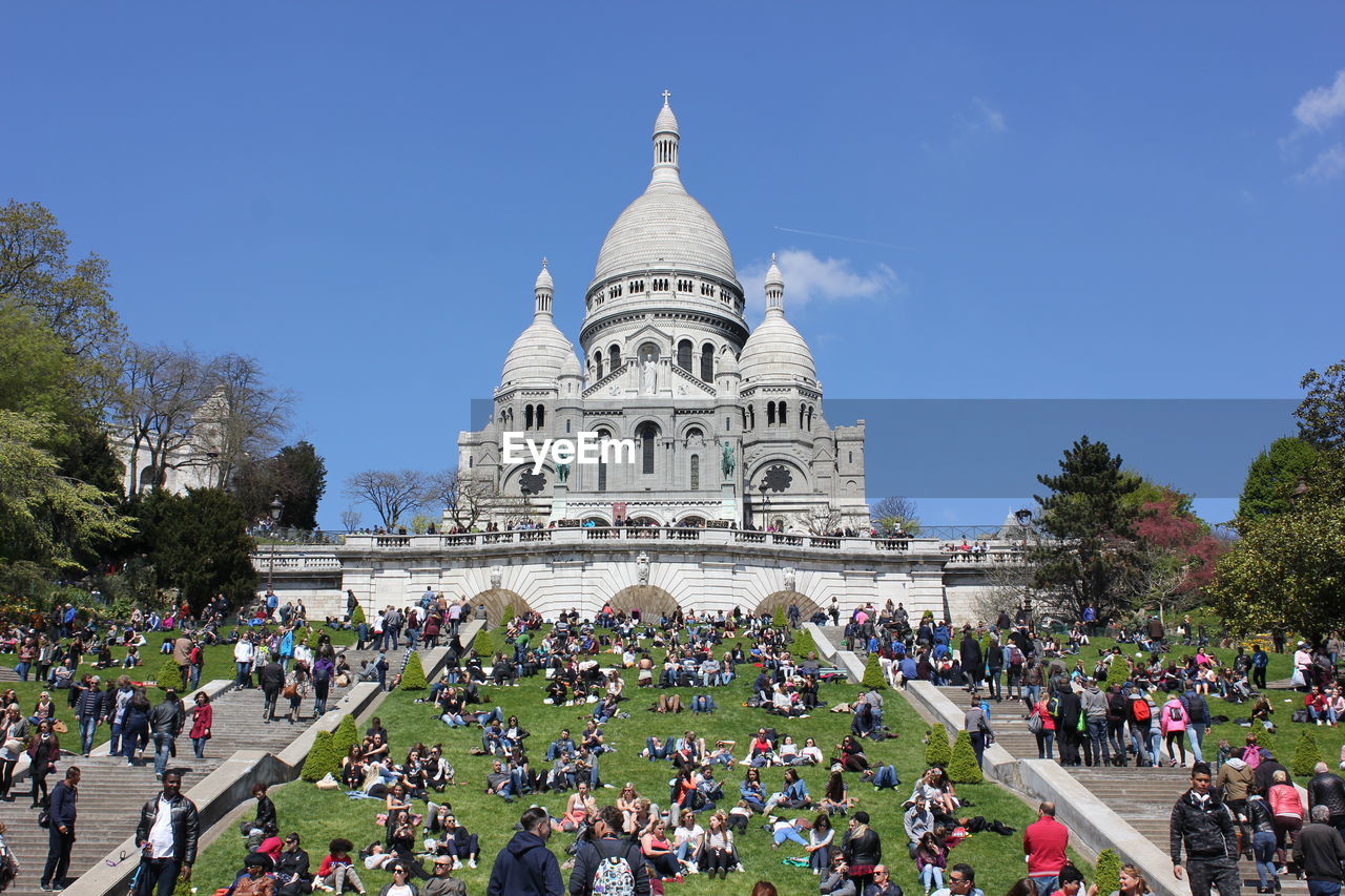 Tourists at basilique du sacre coeur against sky