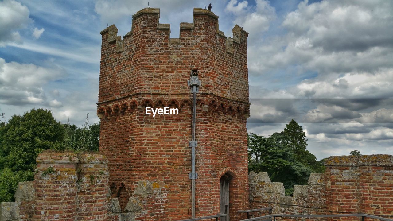 LOW ANGLE VIEW OF OLD BUILT STRUCTURE AGAINST CLOUDY SKY