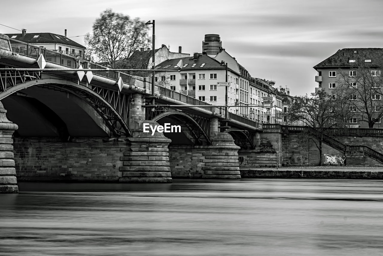 architecture, built structure, bridge, black and white, cityscape, monochrome, monochrome photography, building exterior, water, sky, urban area, city, transportation, river, black, nature, cloud, arch, travel destinations, no people, reflection, building, outdoors, waterway, travel, road, street, landmark, white, transport, arch bridge, history