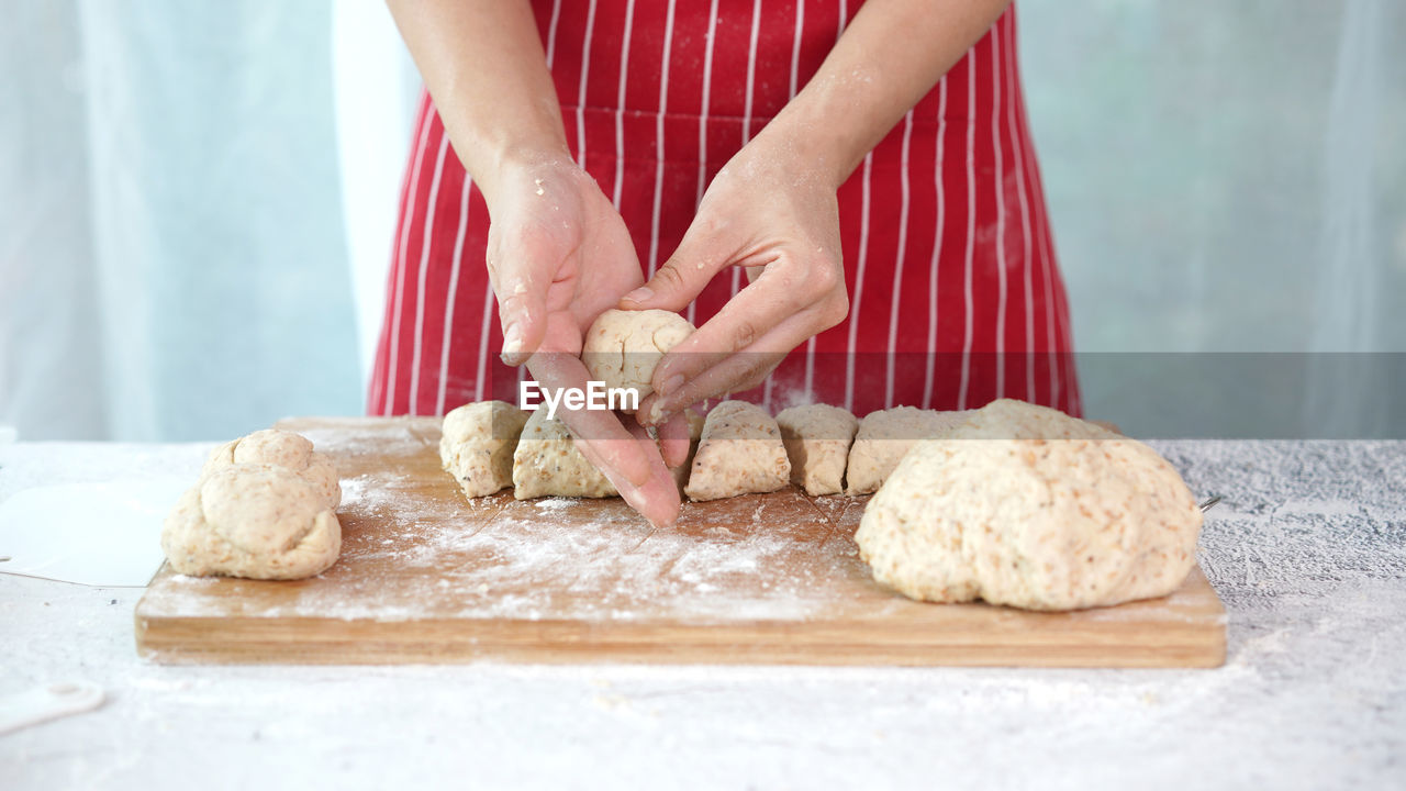 MIDSECTION OF WOMAN PREPARING BREAD