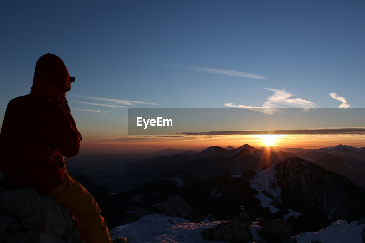 Man looking at mountains during sunset