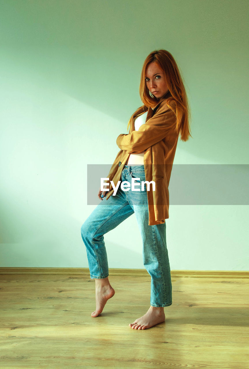 portrait of young woman standing on hardwood floor