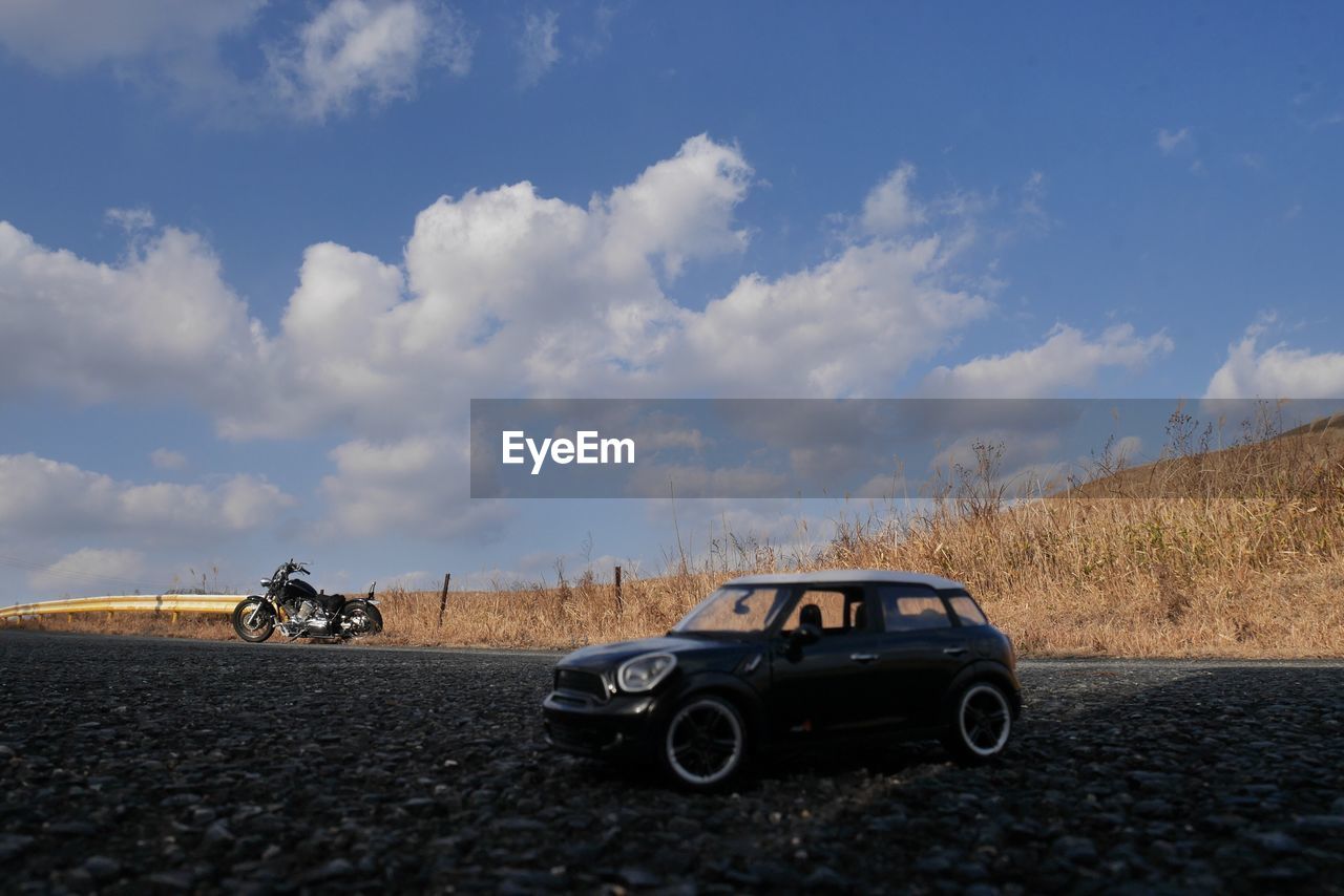 CAR ON ROAD AGAINST SKY