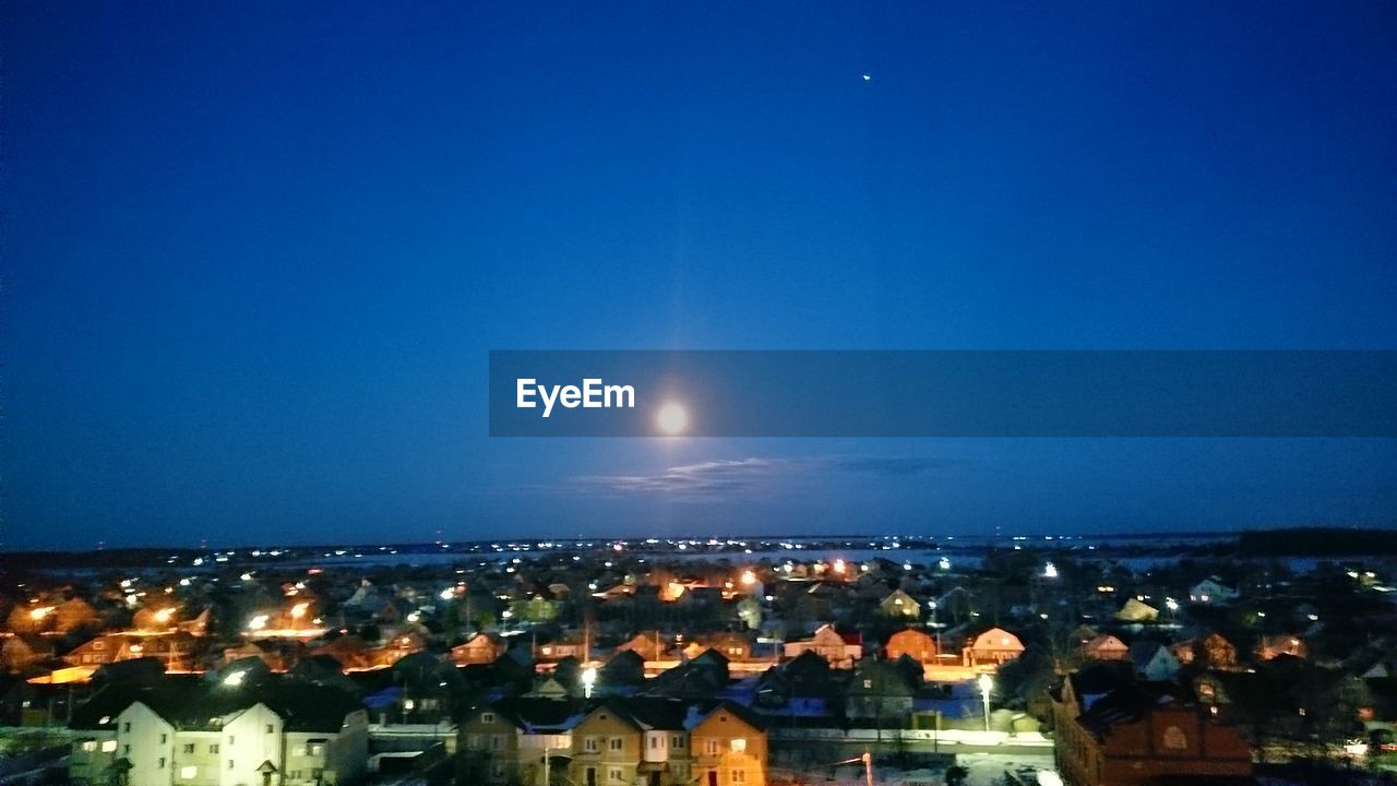 VIEW OF ILLUMINATED CITYSCAPE AT NIGHT