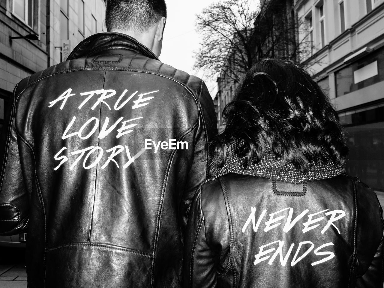 Rear view of couple walking with text