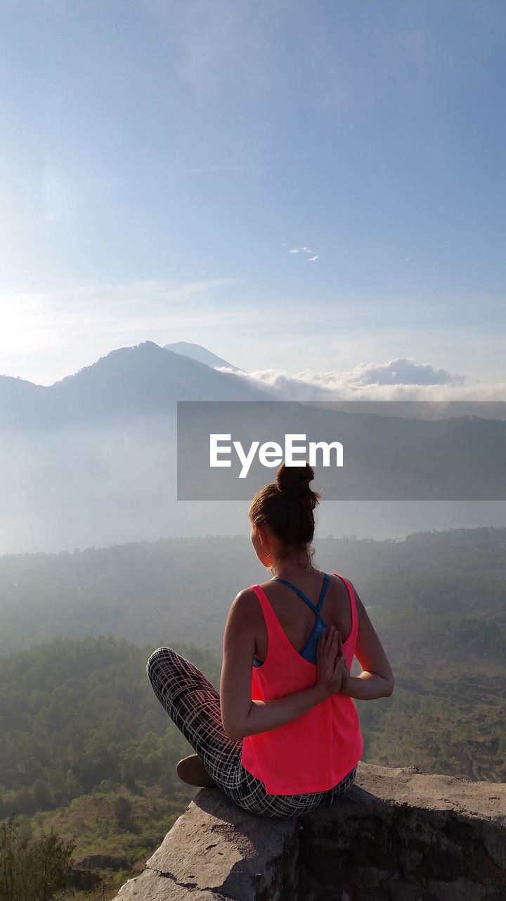 Woman doing yoga against mountains