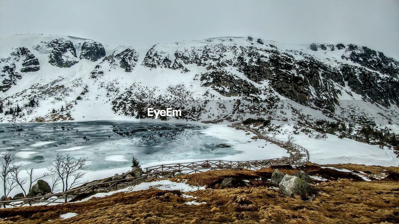 SNOW COVERED ROCKS AGAINST SKY